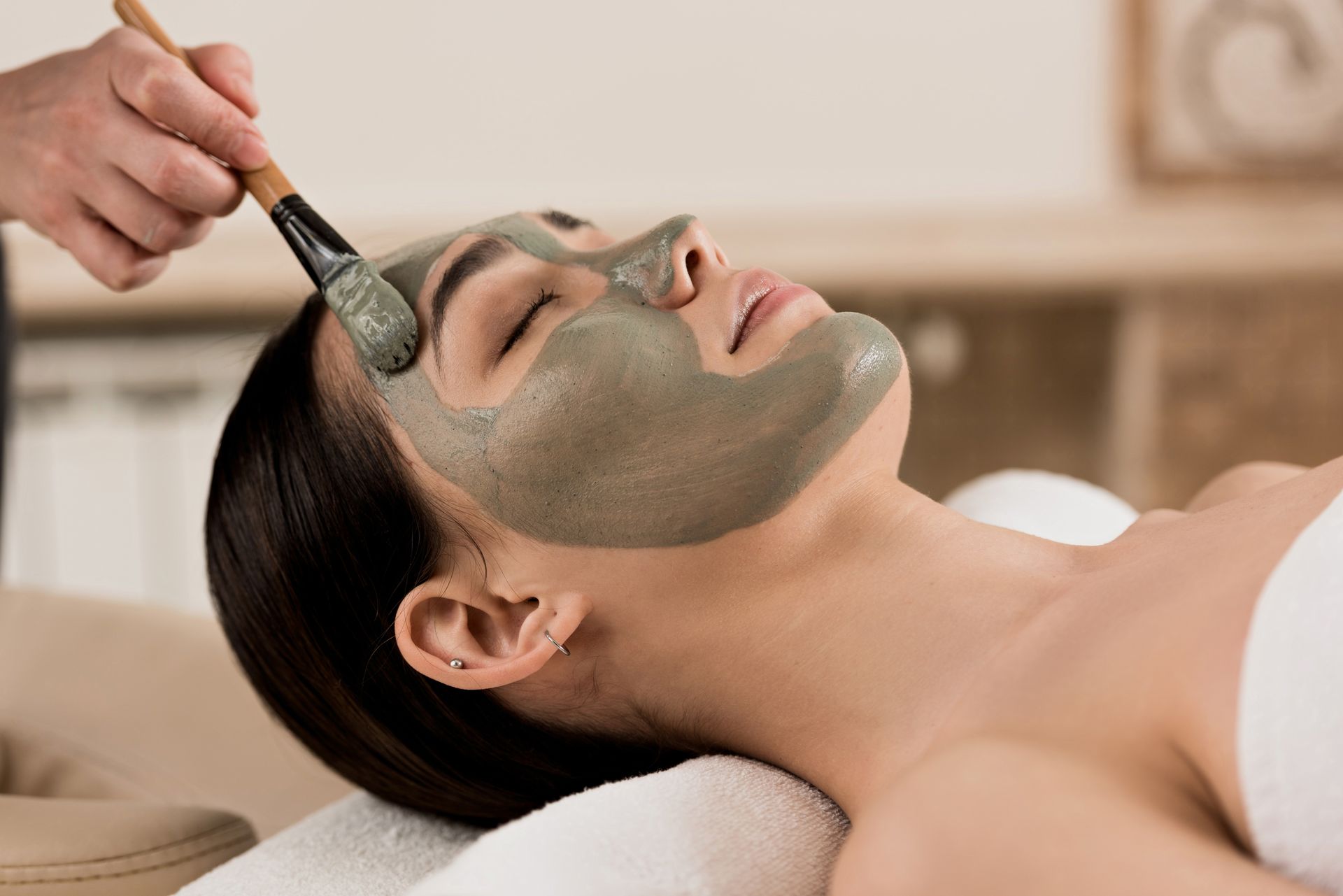 A woman is getting a facial treatment at a spa.