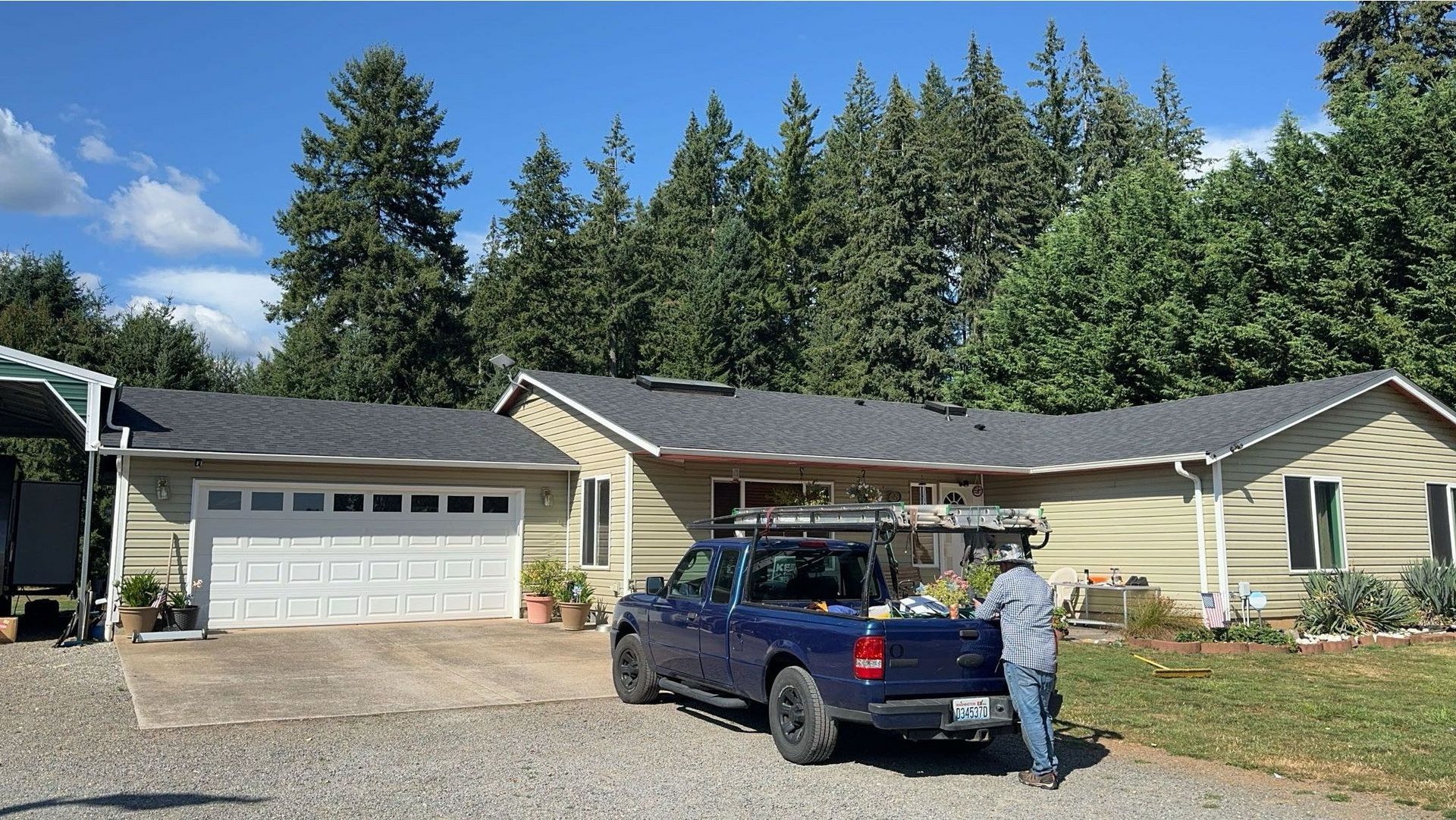 A blue truck is parked in front of a house.