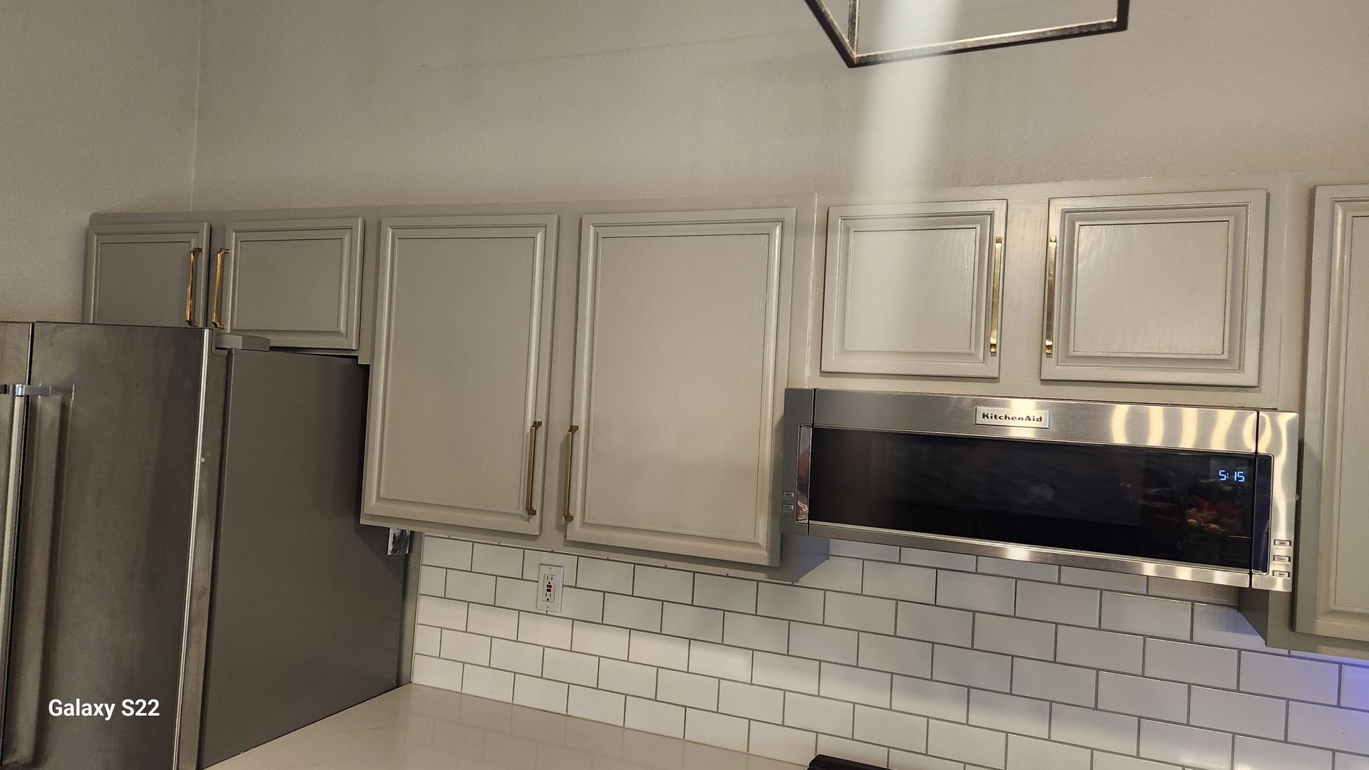 Kitchen with white cabinets, stainless steel appliances, and white subway tile backsplash.