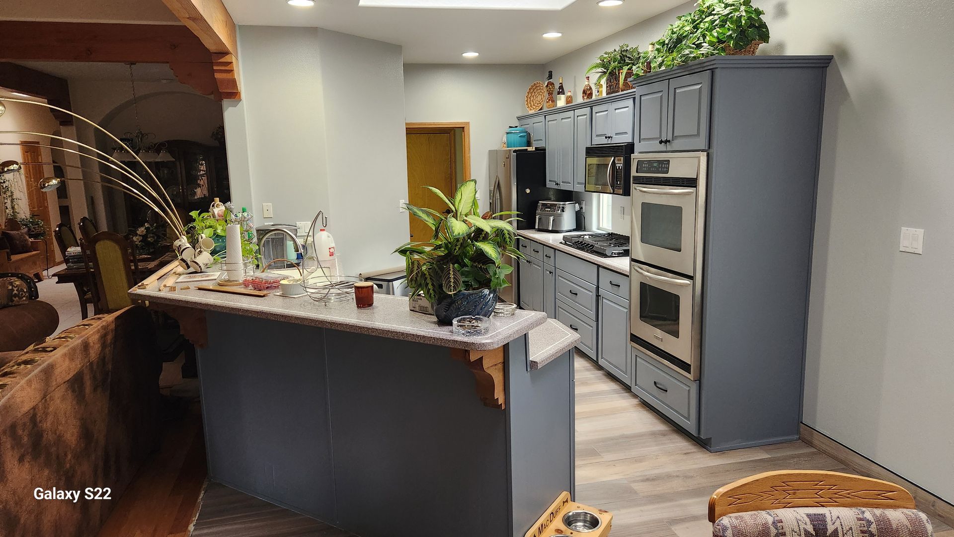 Kitchen with blue cabinets, breakfast bar, and stainless steel appliances.