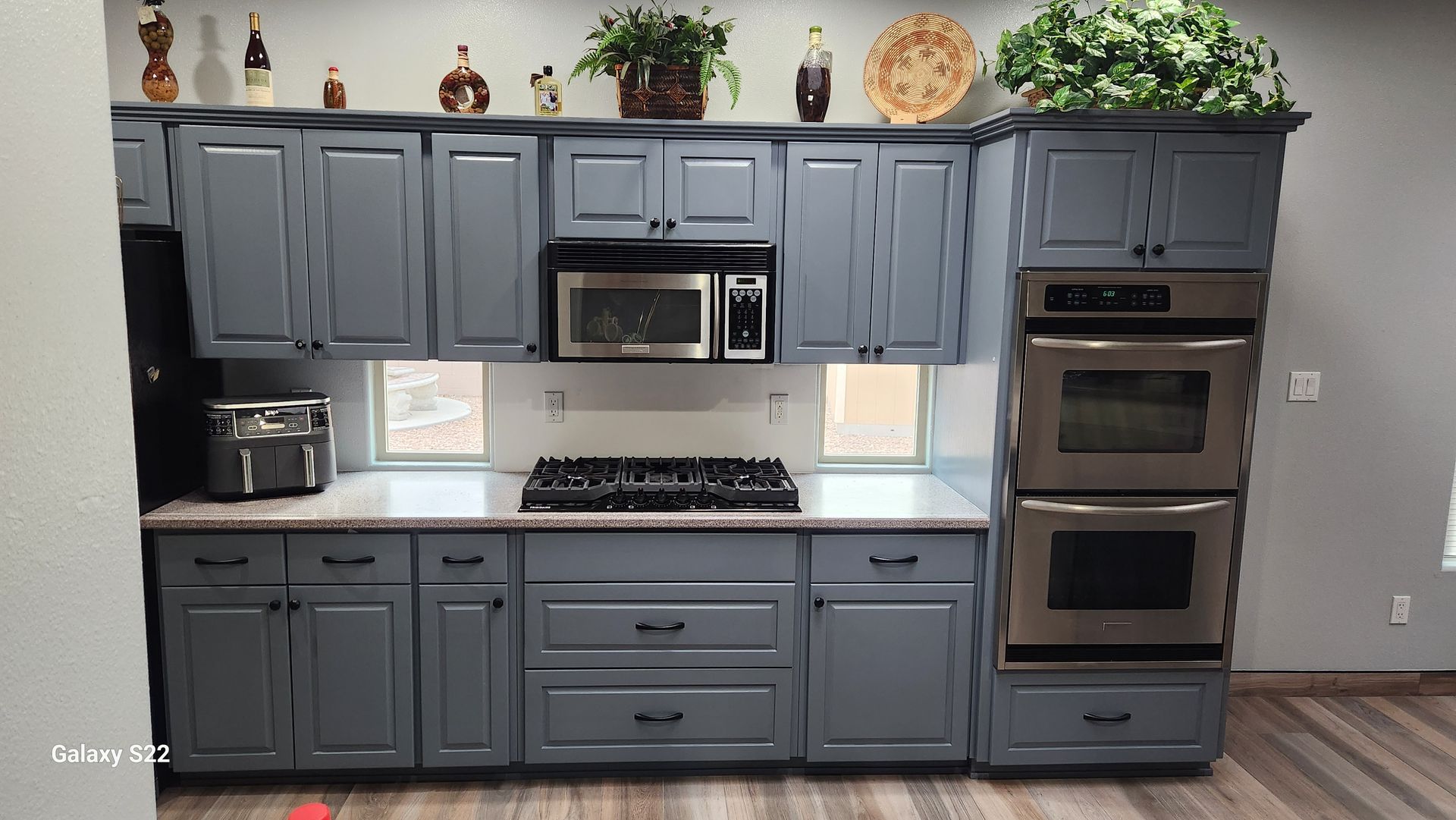Gray kitchen cabinets with a microwave, oven, and stovetop.