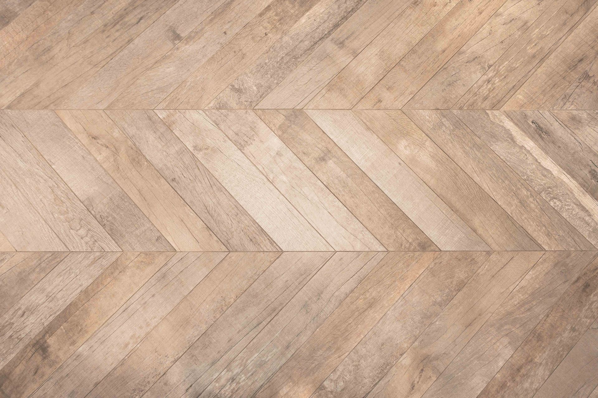 Light brown herringbone patterned wood flooring.
