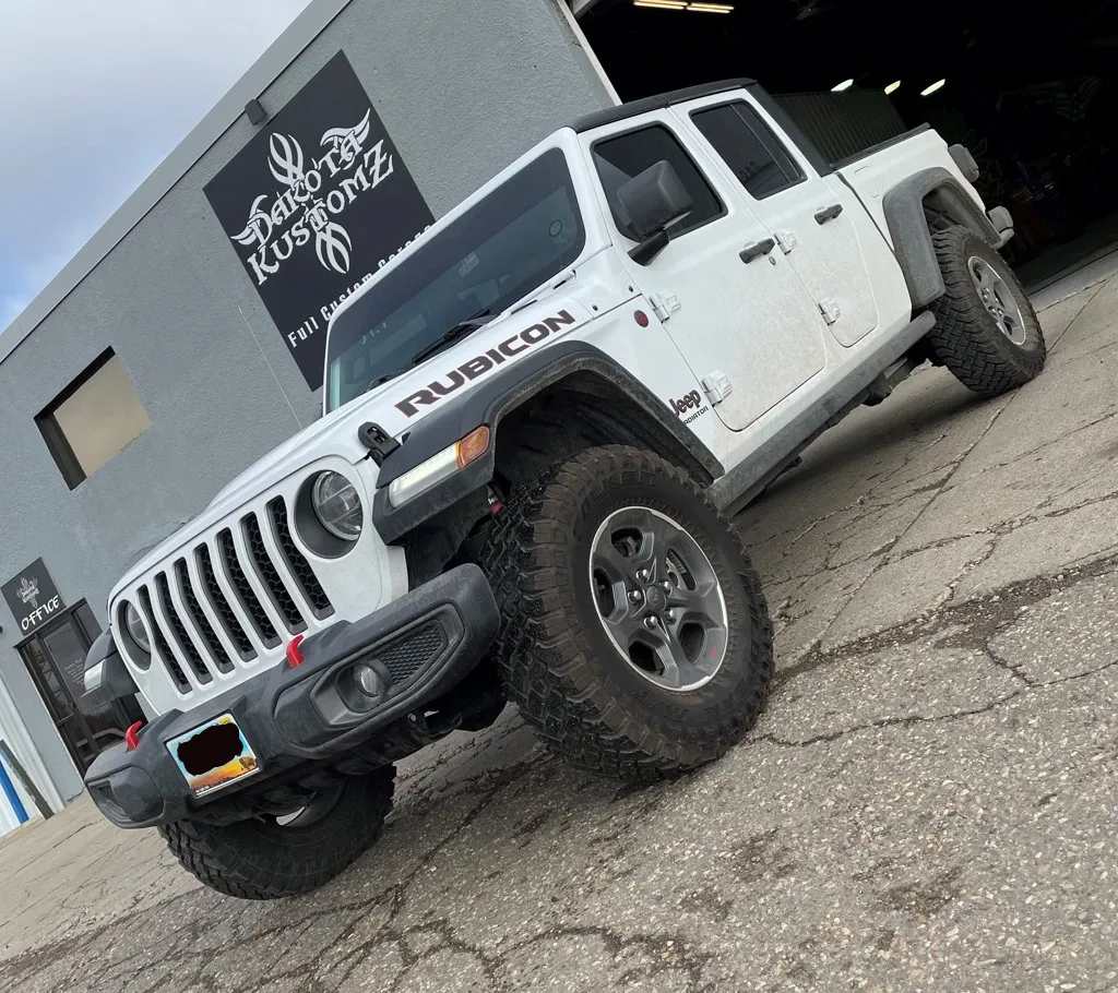 custom 2020 white jeep gladiator in front of dakota kustomz garage