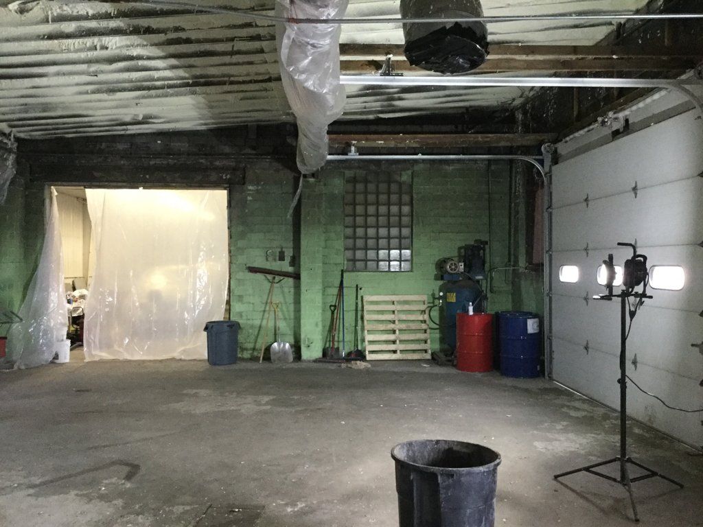 room with tools against wall with garbage can in foreground