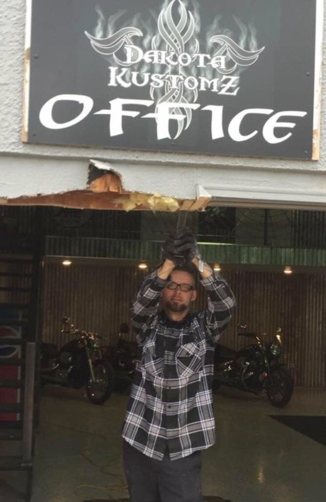 dakota kustomz office sign above newly demolished building wall