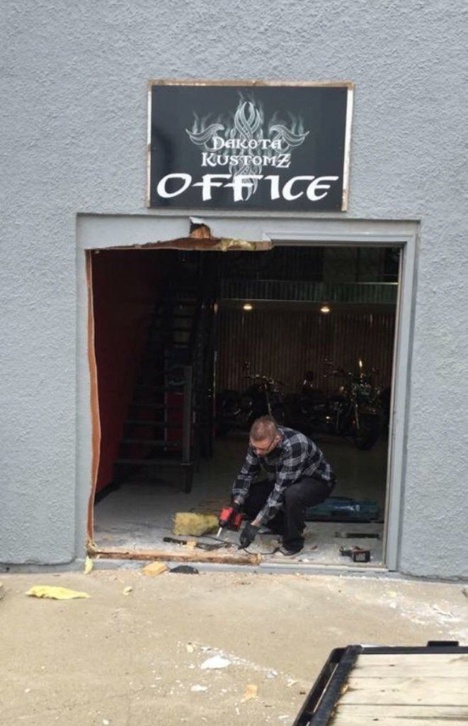 dakota kustomz office sign above newly demolished building wall