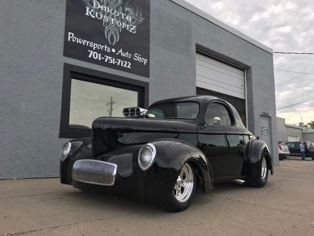 customized black 1941 willys coupe hot rod in front of dakota kustomz garage