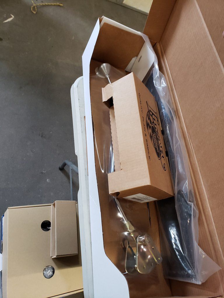 boxes and plastic inside narrow box on garage floor