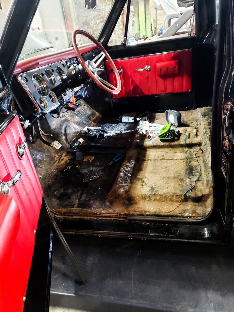 driver side view of front seat with driver's seat removed and tools on truck floor