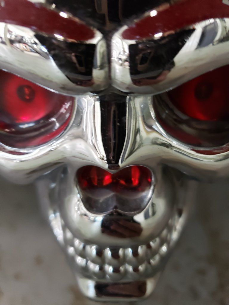 top front view of customized chrome skull with red eyes and nose