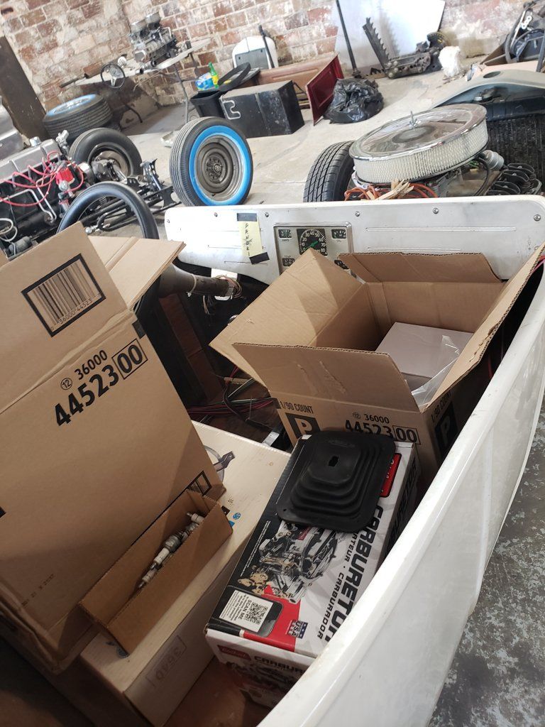 boxes of parts inside of customized white hot rod