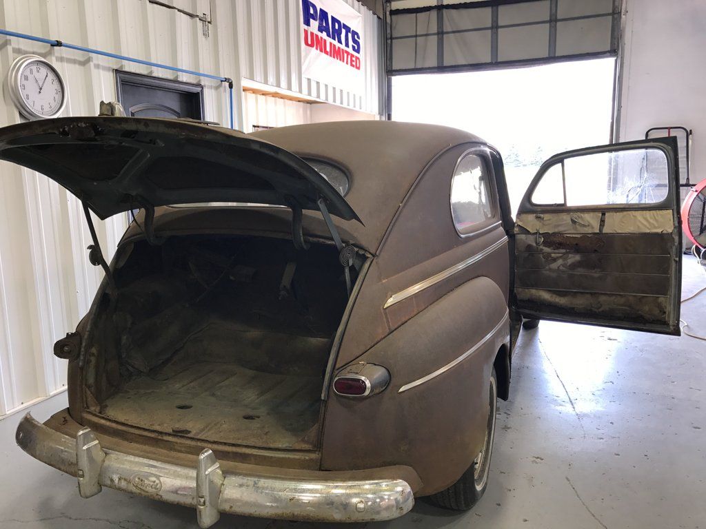 rear view of sedan with trunk open and car doors open