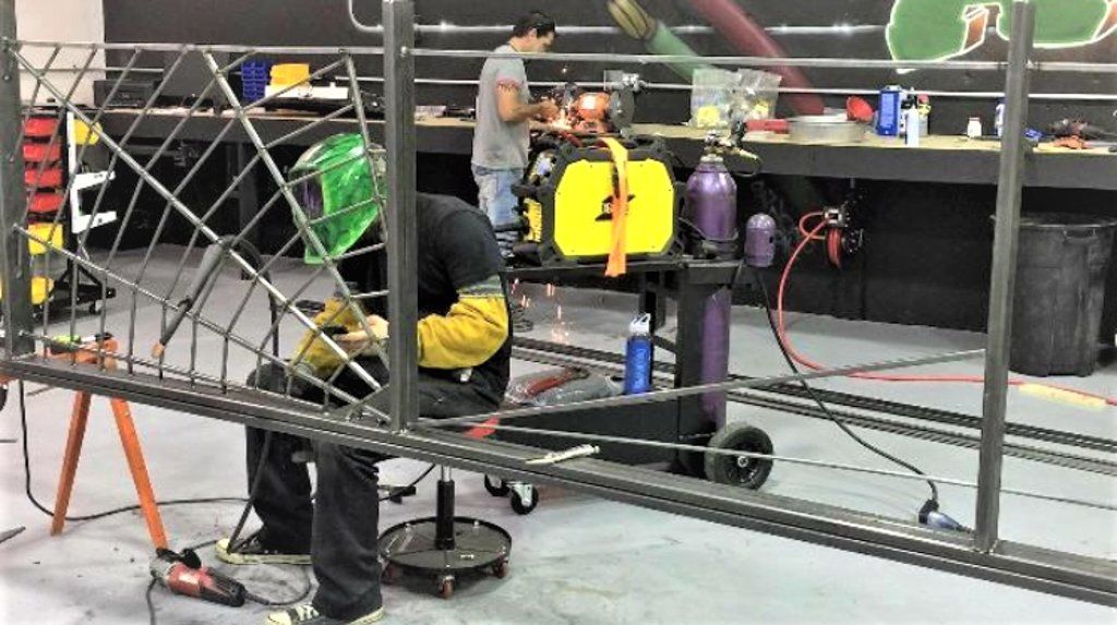 worker welding together custom railing for dakota kustomz