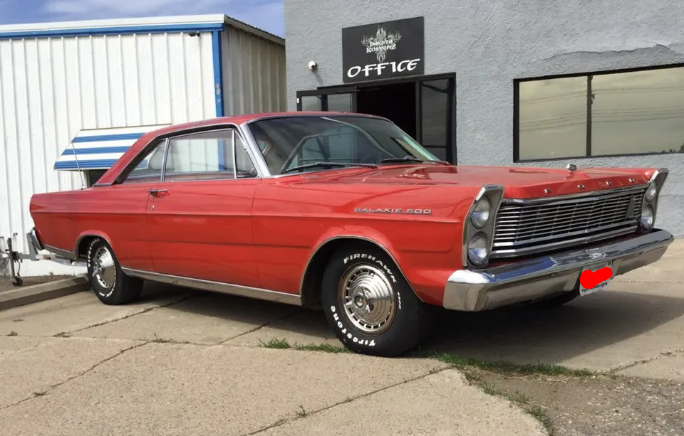 customized red 1965 ford galaxie muscle car in front of dakota kustomz garage
