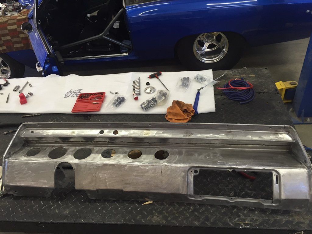 car part on service bay with parts on workbench