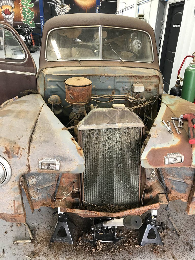front view of rusted and mangled car before restoration