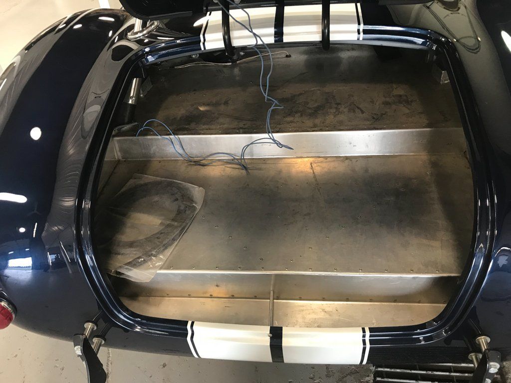 empty metal trunk with blue wires exposed