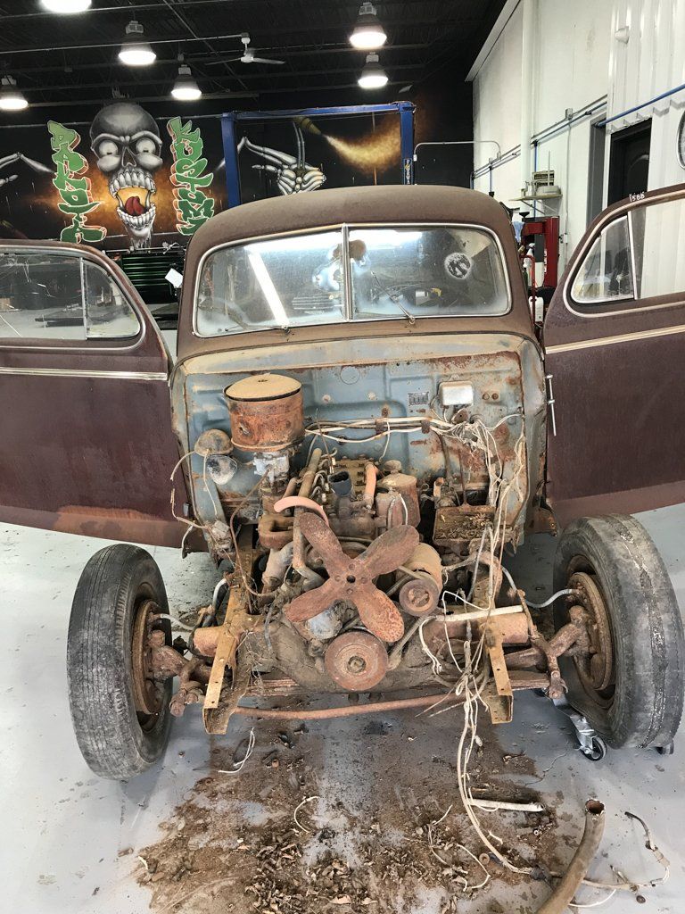 rear view of rusted and mangled car before restoration