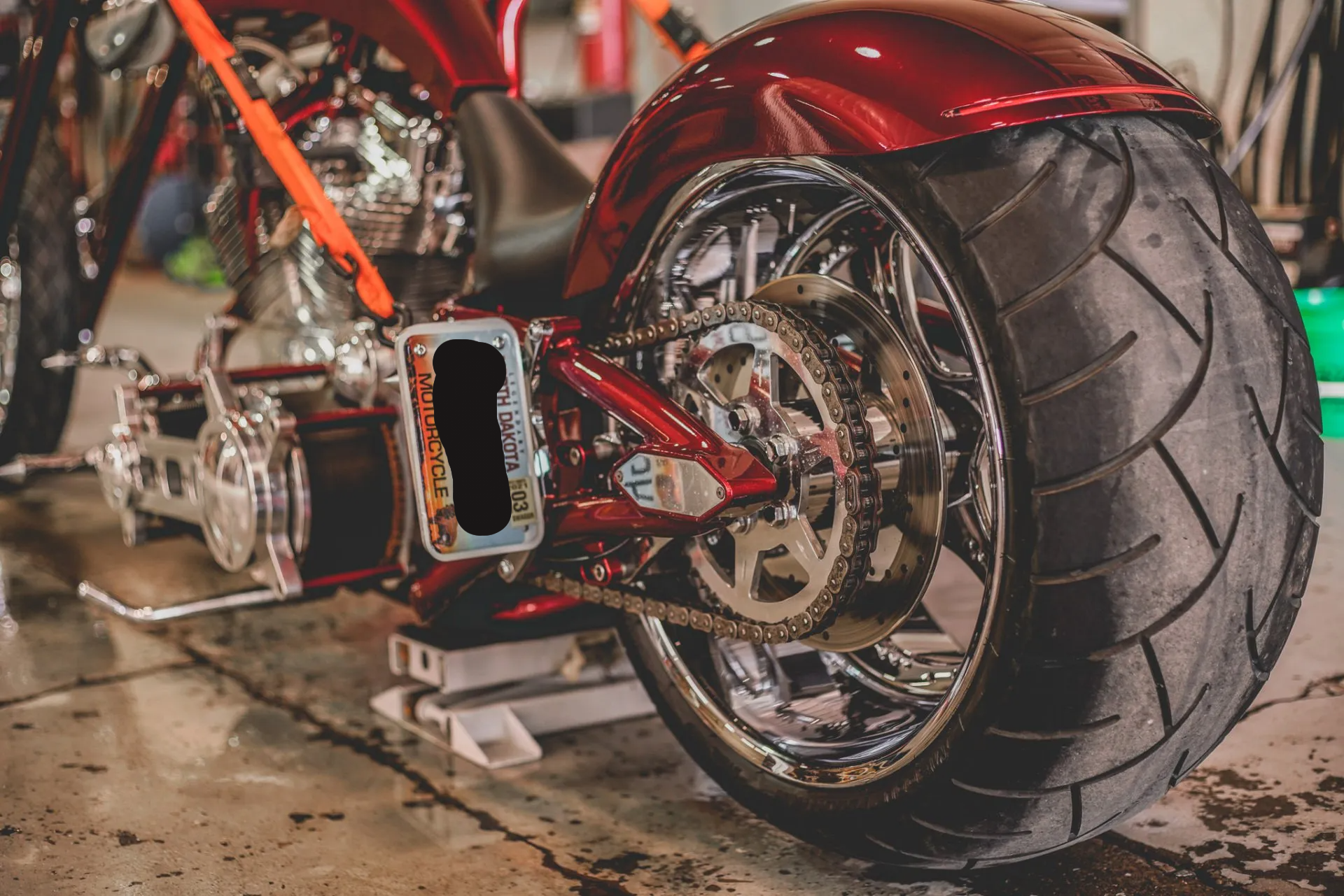 close up of customized red chopper rear wheel with chain