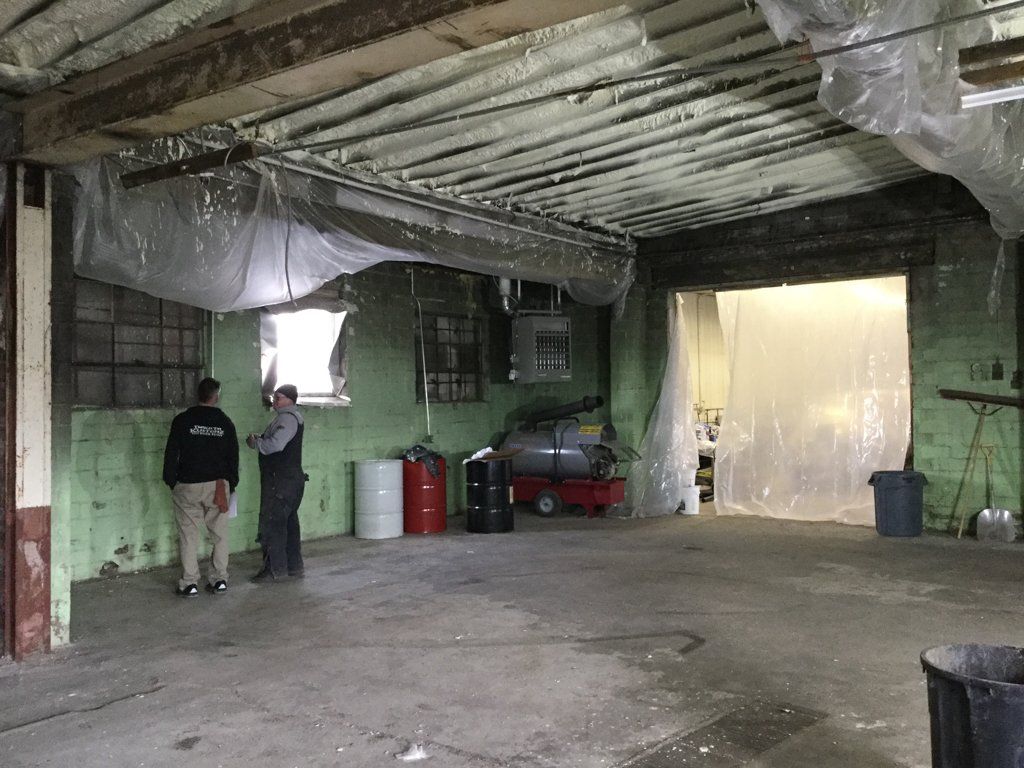 construction workers discussing plans in poorly lit room under construction