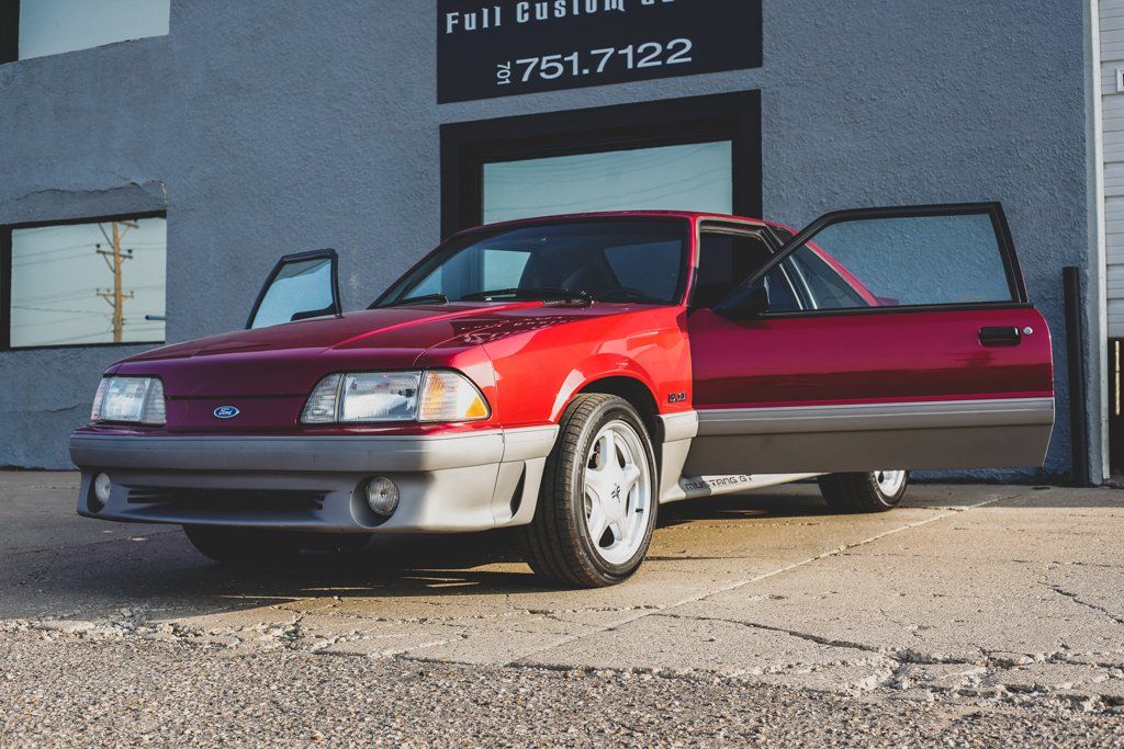 car with doors open in front of dakota kustomz garage