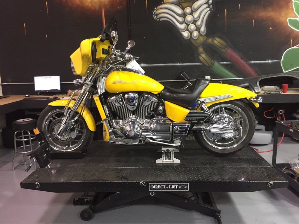side view of yellow motorcycle on direct life service bay