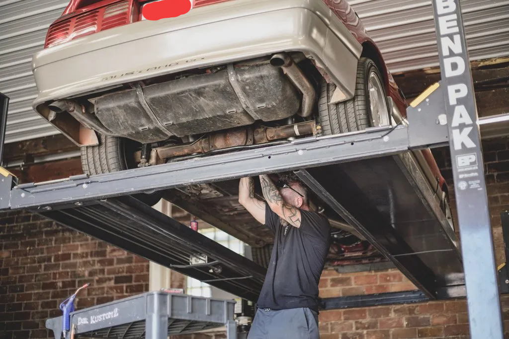 mechanic working underneath car
