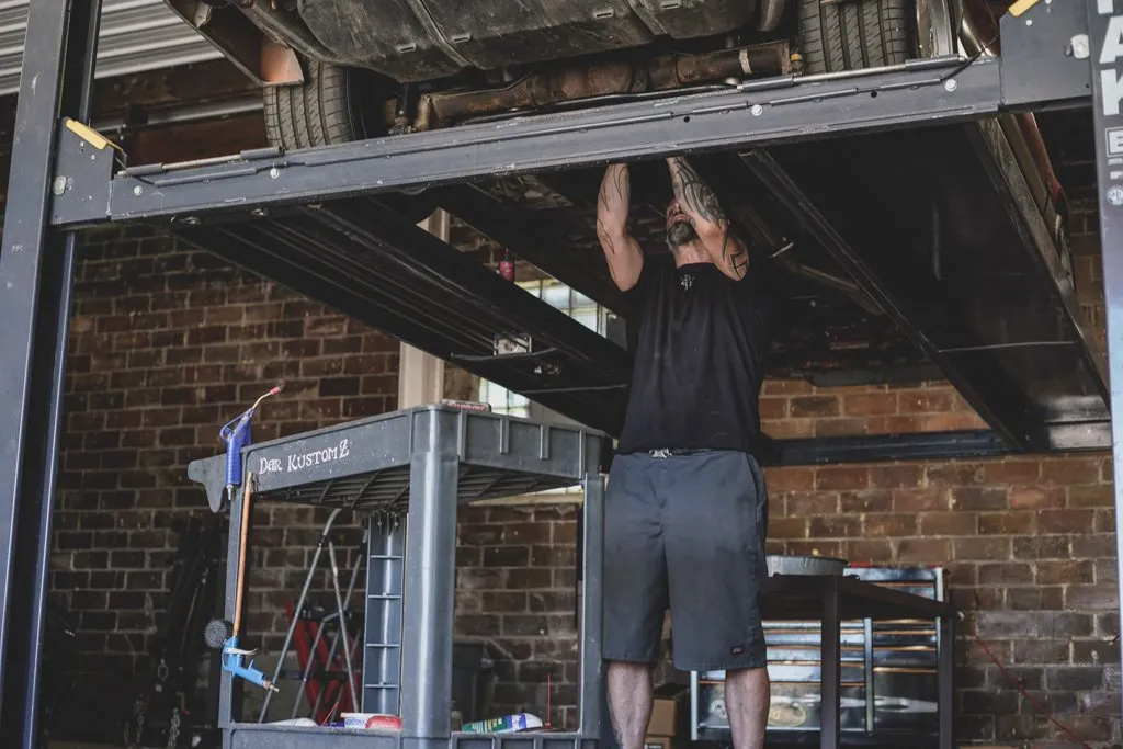 mechanic working underneath car