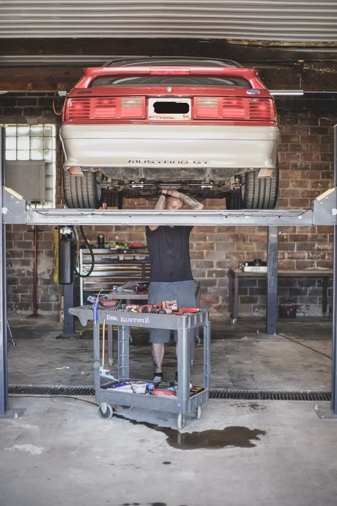 mechanic working underneath car