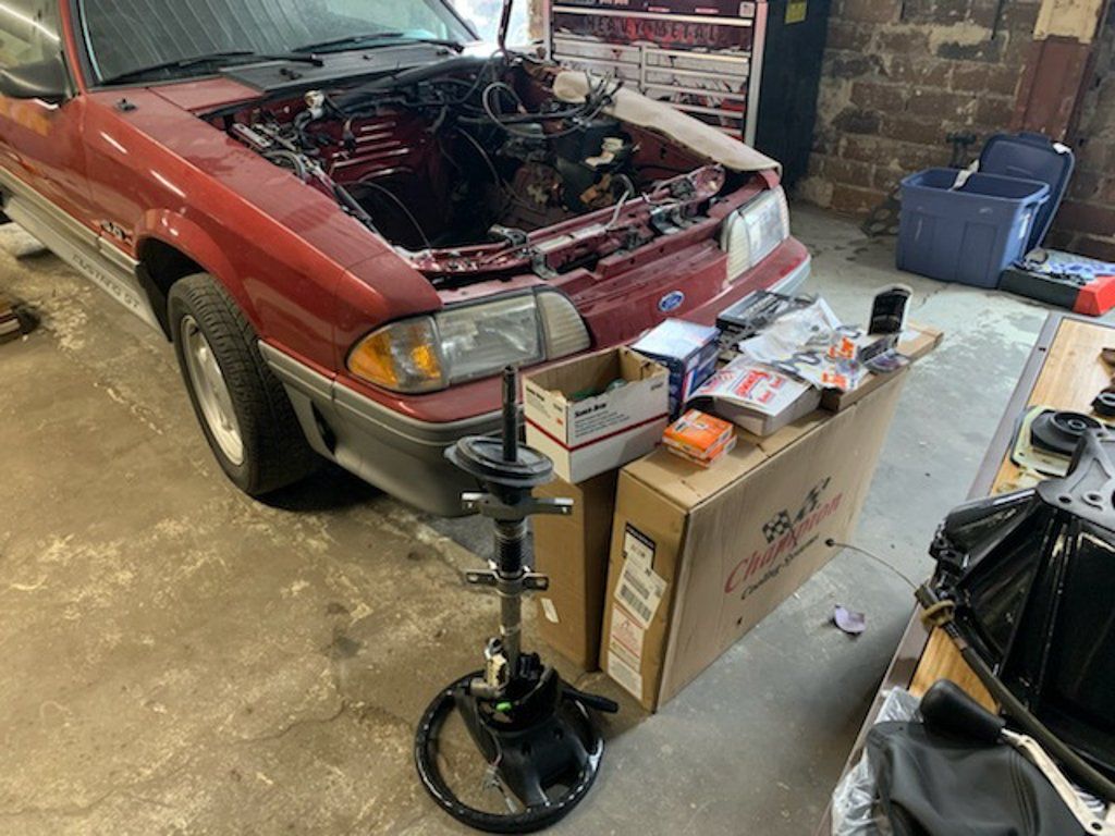 car hood open and missing engine with boxes next to car