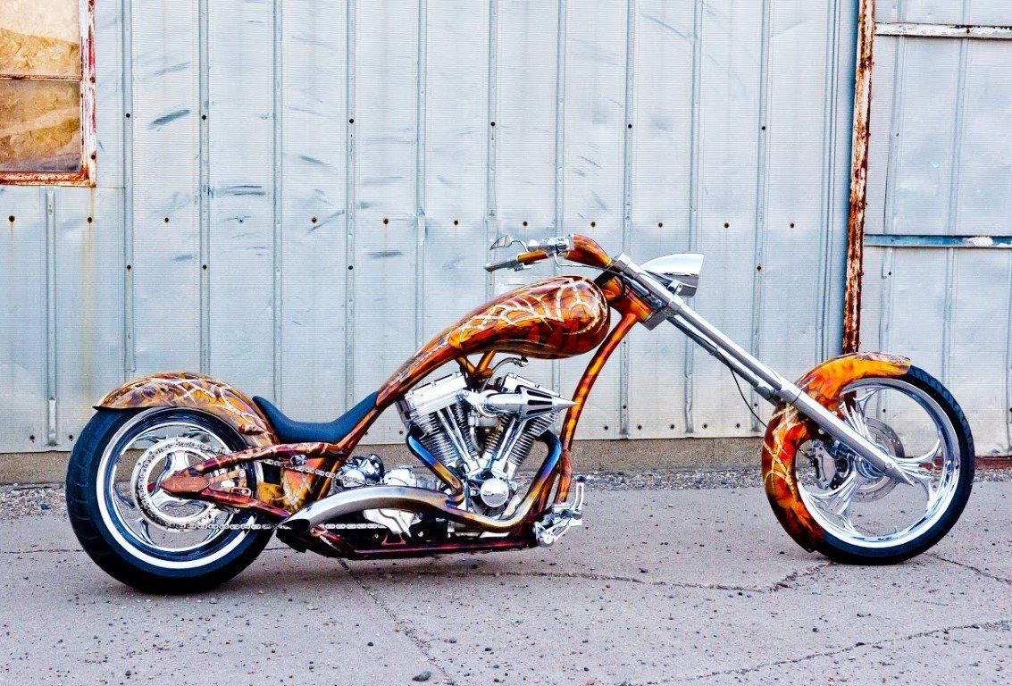 side view of custom orange and red chopper outside