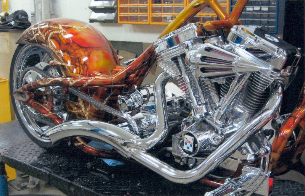 side view of chrome on custom orange and red chopper