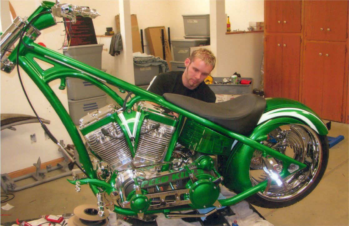 mechanic working on customized green chopper on workbench