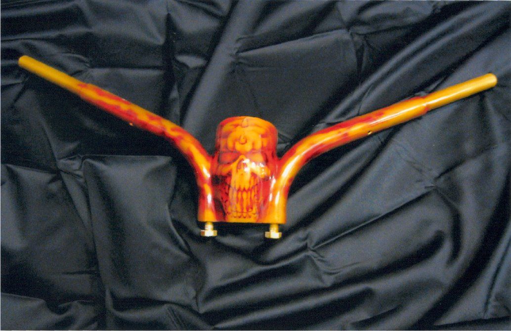 close up of custom chopper red and orange handles with skull design