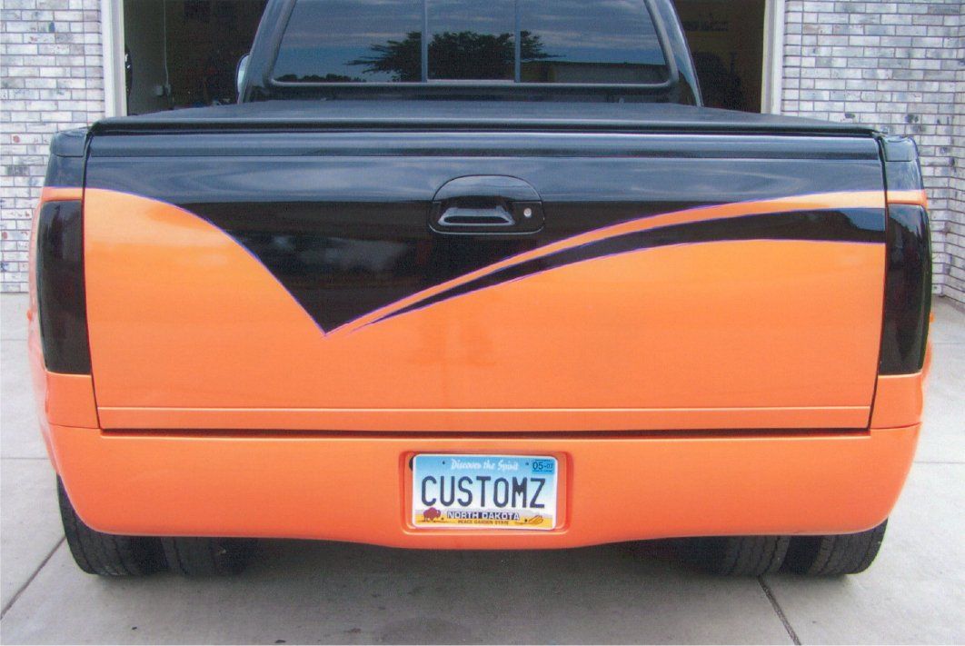 rear view of orange and black customized pickup truck with license plate customz