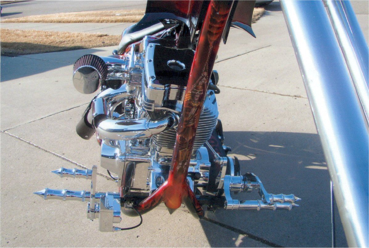 close up of customized artwork of skeleton bound by chains on frame of customized chopper