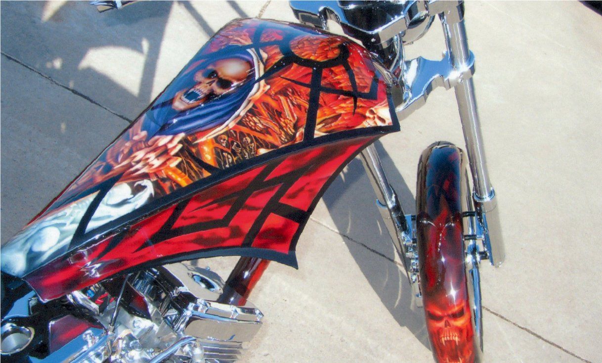 close up of customized gothic style red and orange skull design on fuel tank cover