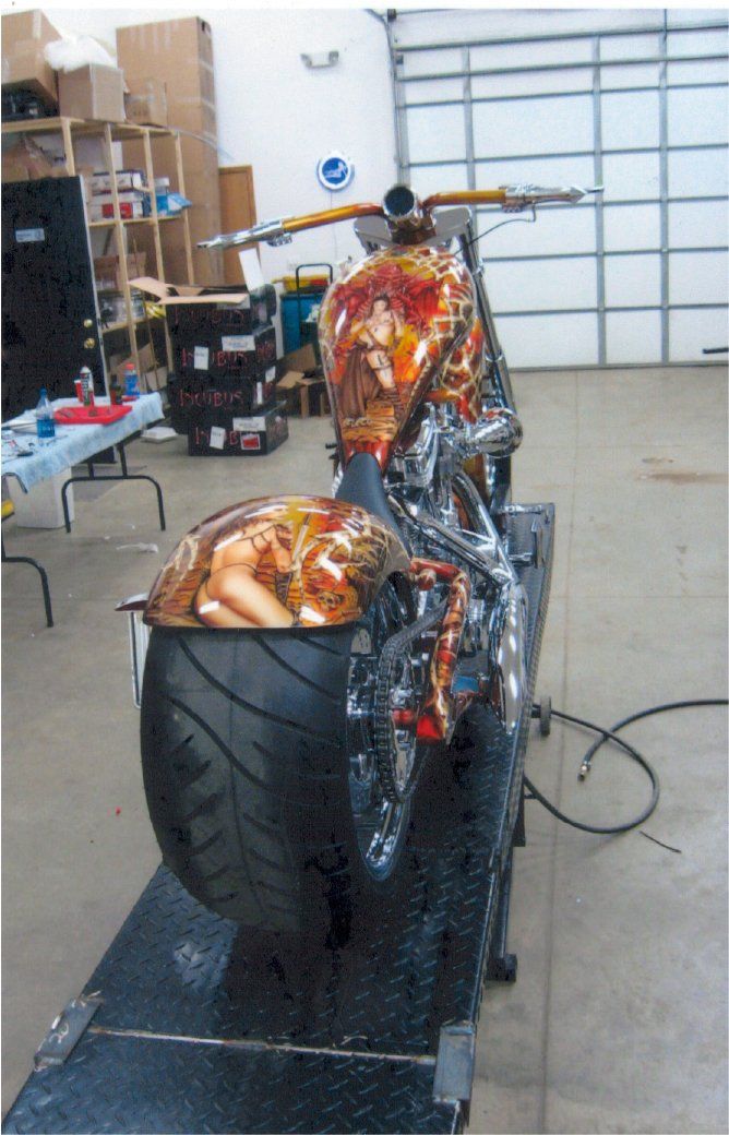 rear view of customized custom orange and red chopper on service bay