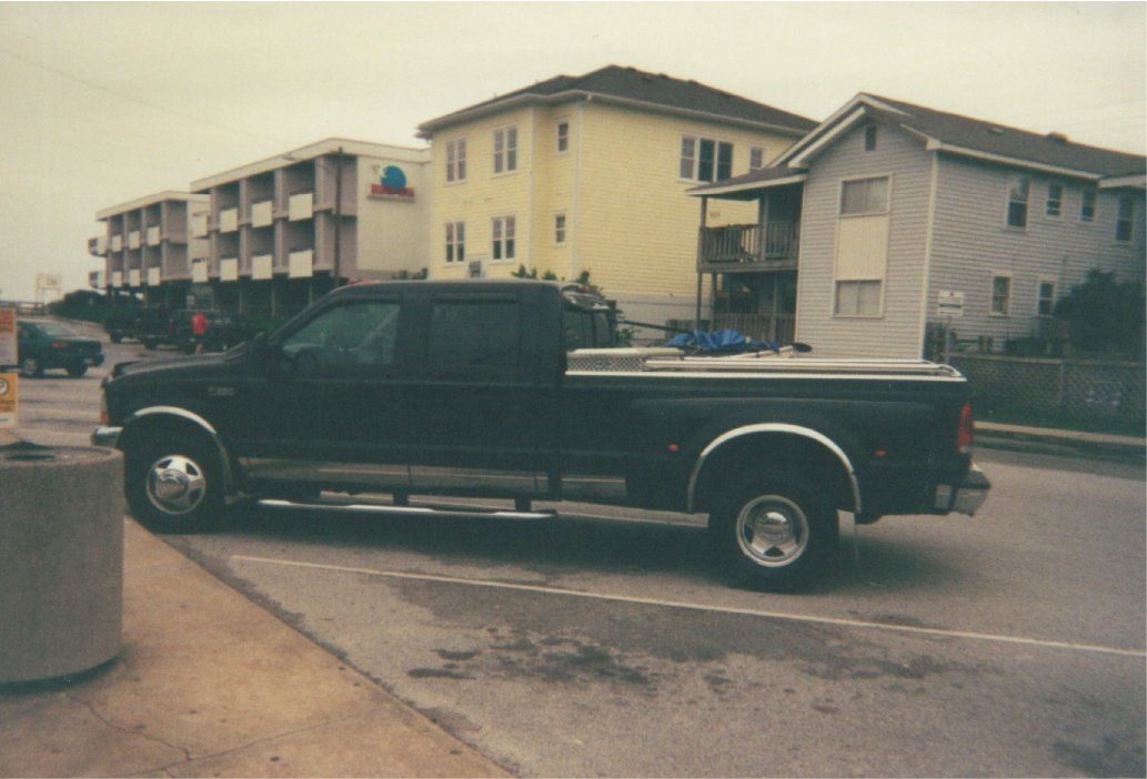 drive side view of black ford pickup before customization in parking lot in front of residential building
