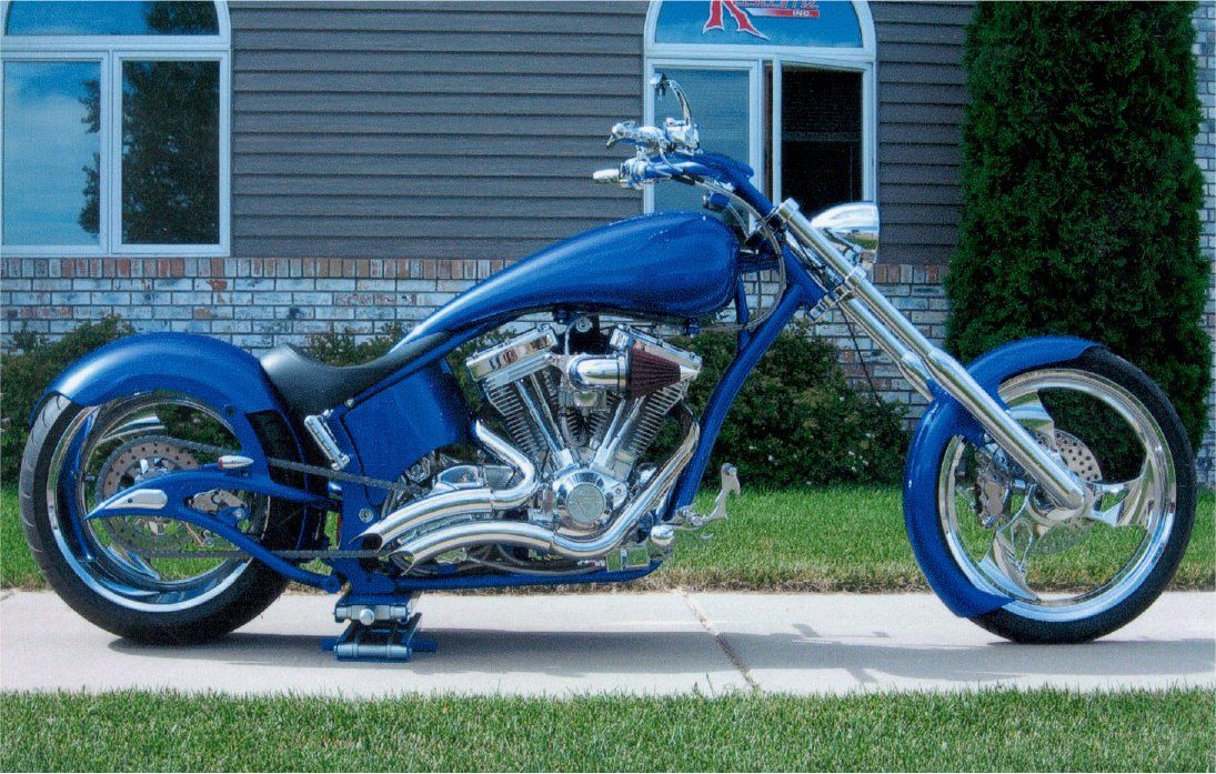 side view of blue motorcycle in front of dakota kustomz office