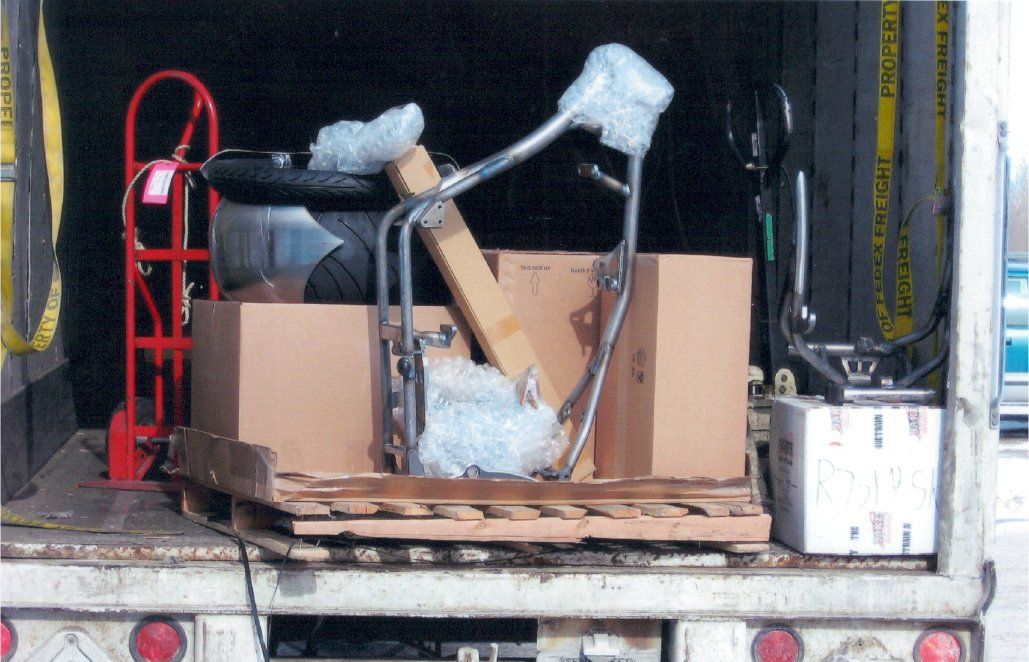 motorcycle part on wooden palatte with boxes