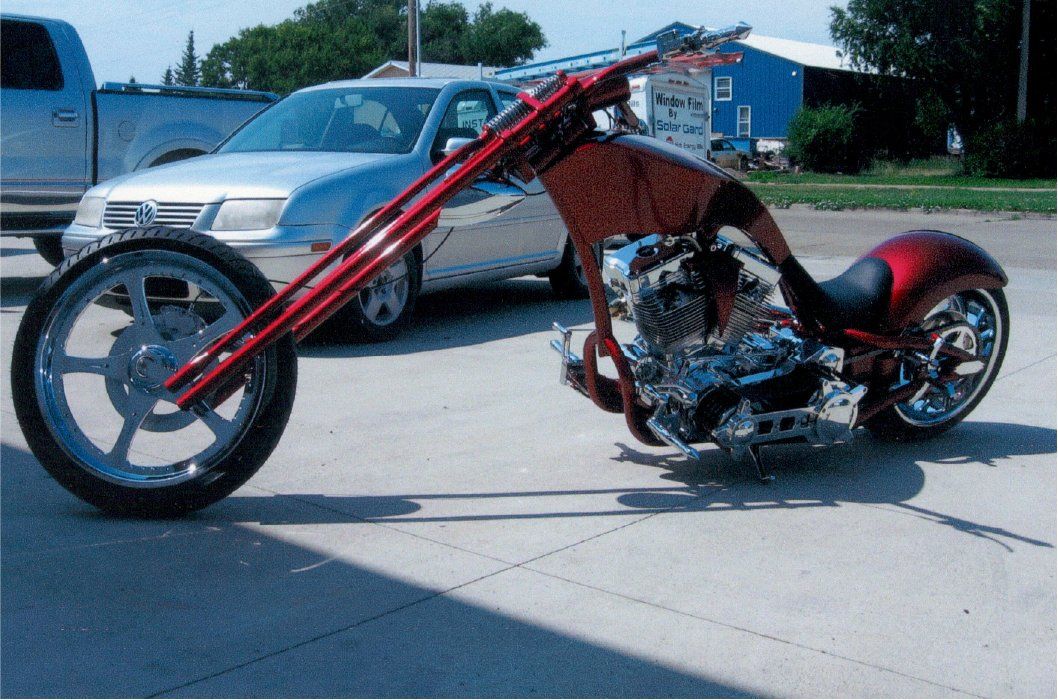 front side view of customized red chopper in driveway