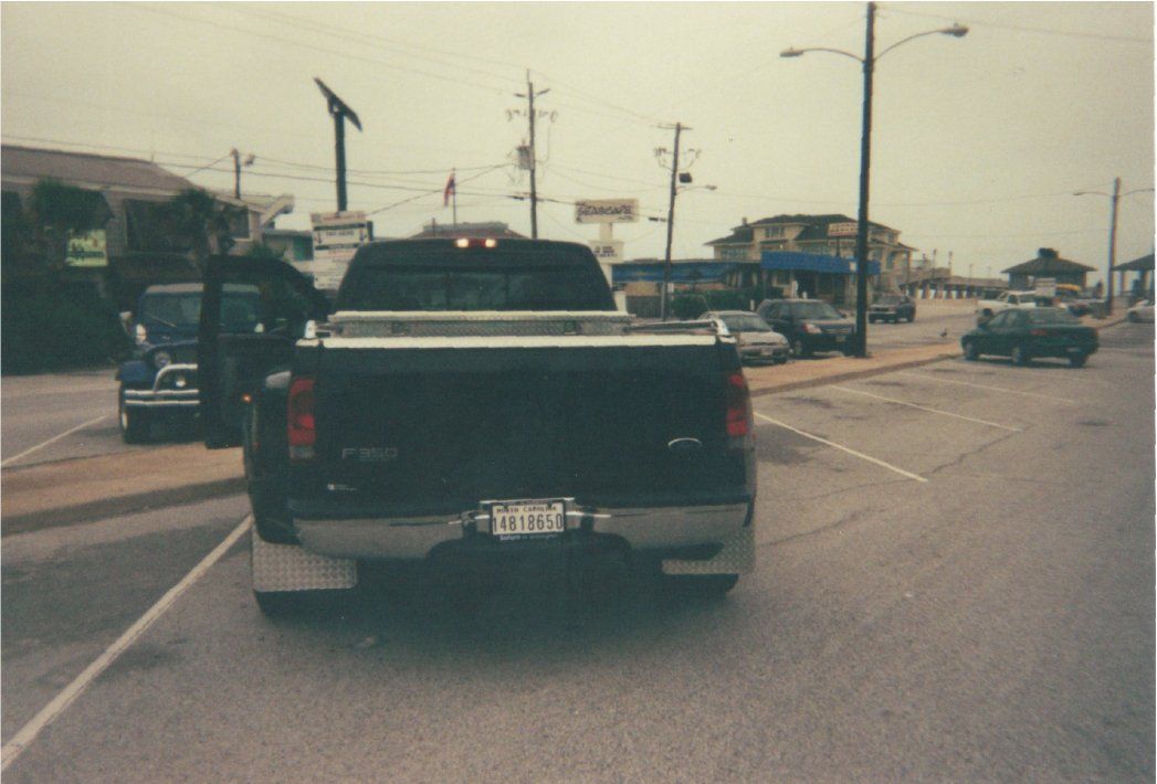rear view of black ford pickup before customization in parking lot