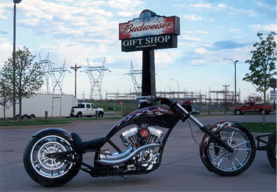 chopper in front of tall budweiser gift shop sign in background