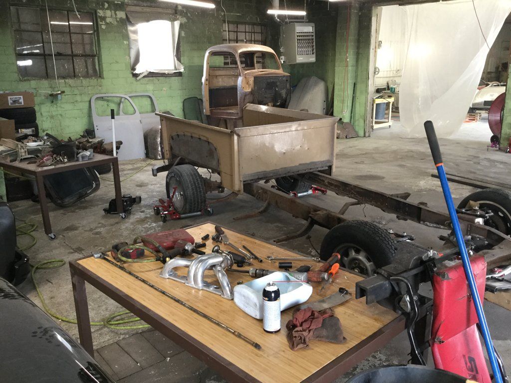 full view of truck chassis with wheels and bed on service bay