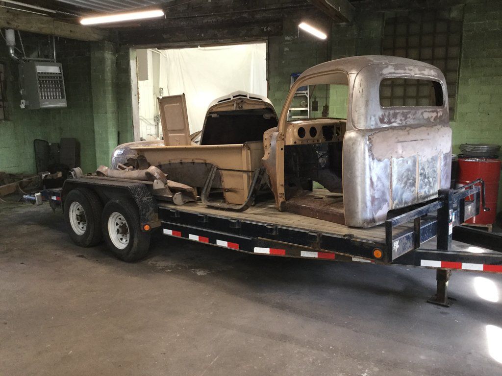 truck parts on flatbed trailer in garage