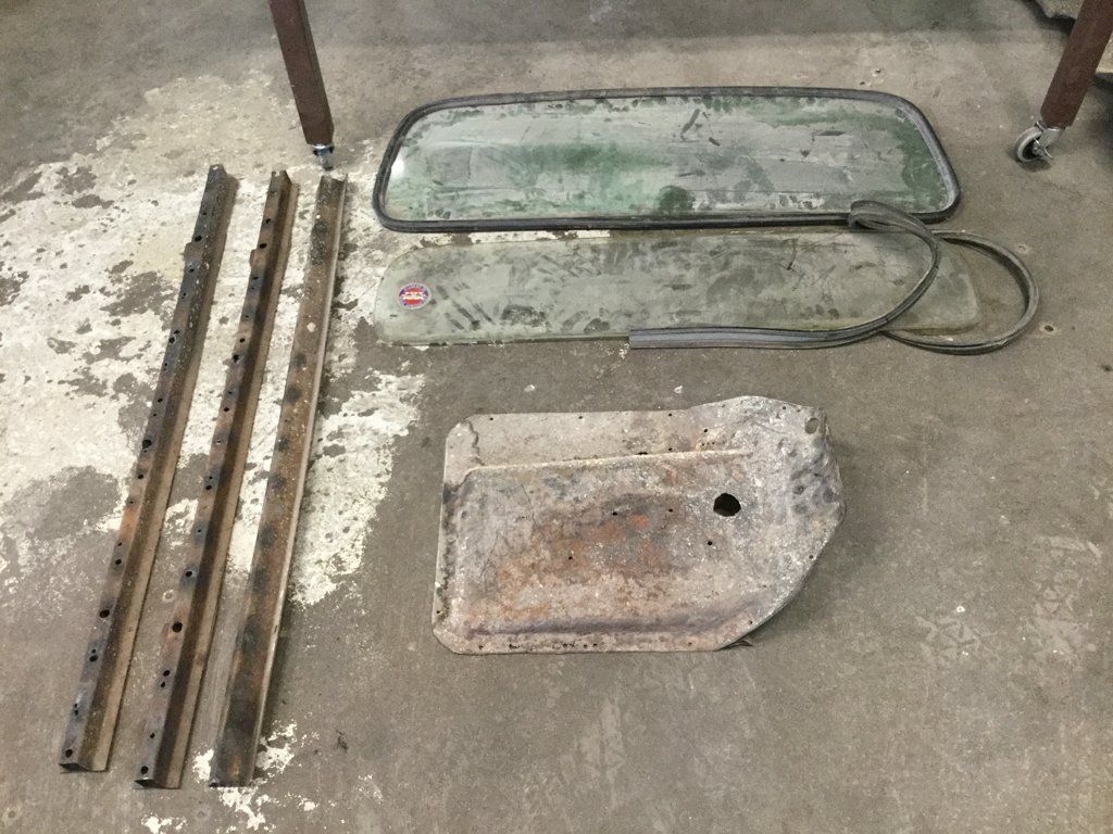 front view of truck glass parts on ground near workbench