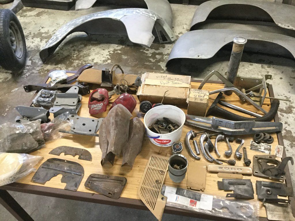 truck parts laid out on floor and work table