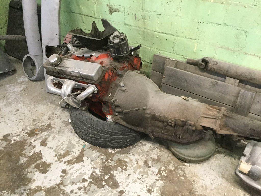 truck engine on tire in corner of garage