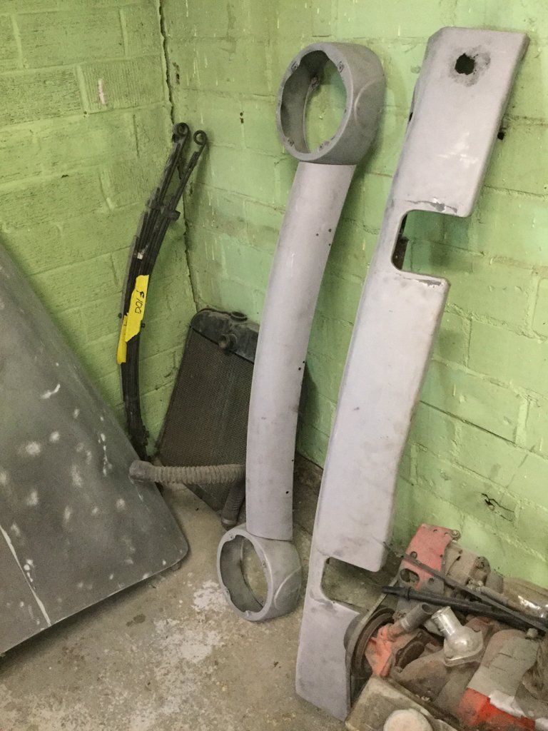 truck headlight fixture and front fender leaning against wall